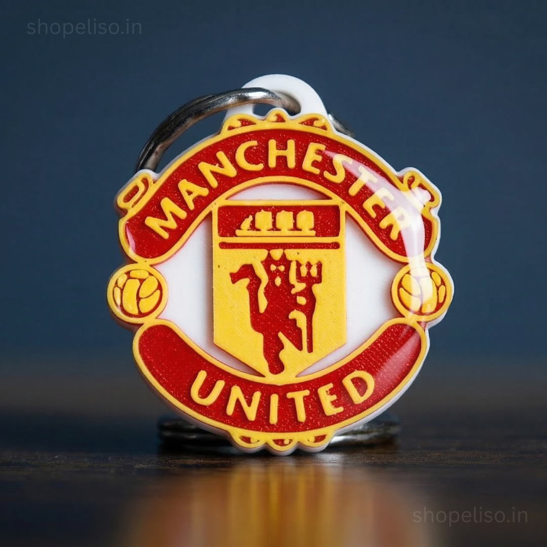 Manchester United keychain with red and yellow colors on a dark background